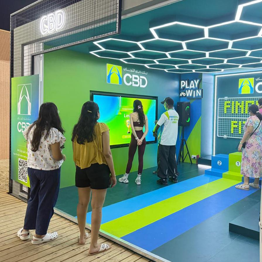 Interactive multi-level touch screen game rental at Dubai 30x30 event, showing guests engaged in a gamified fitness and financial literacy challenge.